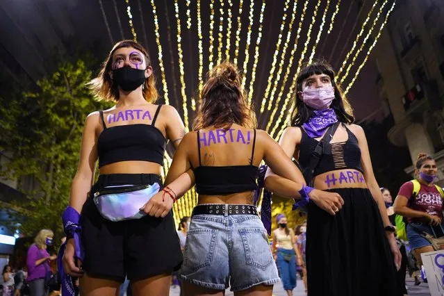 Participants with the word “Harta” on their bodies, link arms as they mark International Women's Day at Avenida 18 de Julio in downtown Montevideo, Uruguay March 8, 2021. The word is a term to say exhausted or “had enough” but used by women. (Photo by Mariana Greif/Reuters)