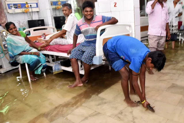 This photograph taken in July 29 shows a relative's patient catching a fish inside a waterlogged hospital ward at Nalanda Medical College and Hospital (NMCH) following heavy monsoon rains in Patna in the Indian state of Bihar. (Photo by AFP Photo/Stringer)