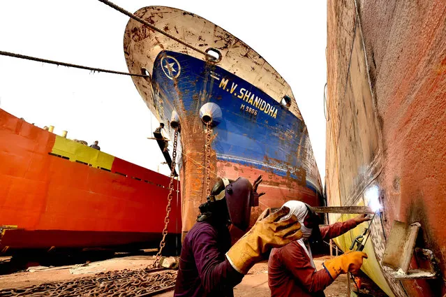 Laborers work at a dockyard in Keraniganj on the outskirts of Dhaka, Bangladesh on March 1, 2021. With dozens of shipyards, Keraniganj on the bank of the river Burigonga that flows past the southwest outskirts of Bangladesh capital Dhaka now seems a mega hub for building and repairing small vessels, launches and steamers. The area never sleeps with hundreds of workers dismantling the cargo ships and cruisers that are no longer in use to reuse their parts in new or repaired ones around the clock. (Photo by Chine Nouvelle/SIPA Press/Rex Features/Shutterstock)