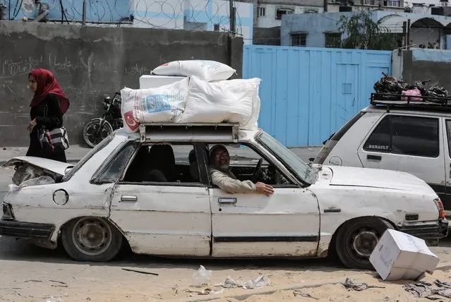 Palestinians sit in a car after they received aids from a United Nations food distribution centre in Jabalia refugee camp in the northern Gaza Strip on August 8, 2018. (Photo by Mahmud Hams/AFP Photo)