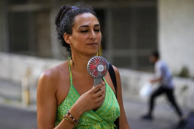 A woman cools off with an electric fan during on a sweltering hot day in Beirut, Lebanon, July 28, 2023. At about summer's halfway point, the record-breaking heat and weather extremes are both unprecedented and unsurprising, hellish yet boring in some ways, scientists say. (Photo by Hassan Ammar/AP Photo)