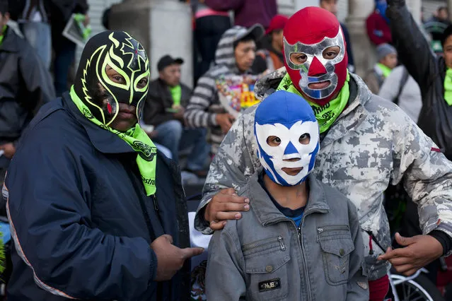 A family of pilgrims, wearing wrestling masks, poses for photos prior a pilgrimage from Guatemala City to the church of the Black Christ of Esquipulas, Saturday, February 7, 2015. (Photo by Moises Castillo/AP Photo)