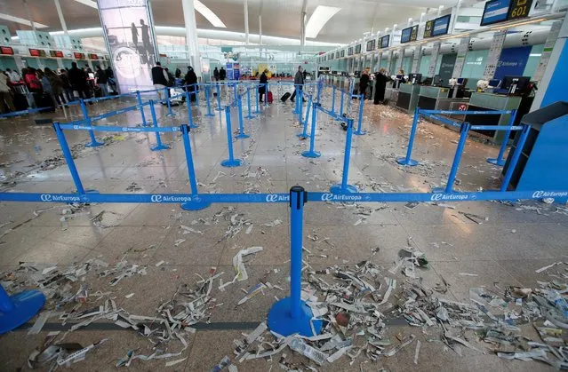Passengers walk in front of AirEuropa check-in desks as the floor is littered with pieces of paper during a protest by the cleaning staff at Barcelona's airport, Spain, December 1, 2016. (Photo by Albert Gea/Reuters)