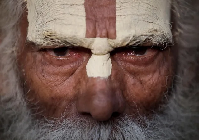 A Hindu holy man, or sadhu, with tika on his forehead looks on as he sits at the premises of Pashupatinath Temple during the Shivaratri festival in Kathmandu, Nepal on March 11, 2021. (Photo by Navesh Chitrakar/Reuters)