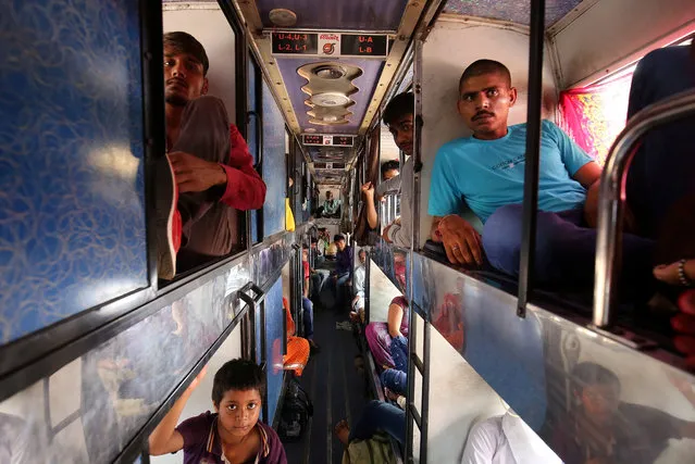 Migrant workers from Madhya Pradesh and Uttar Pradesh are seen sitting inside a bus as they prepare to depart, in Ahmedabad, October 10, 2018. (Photo by Amit Dave/Reuters)