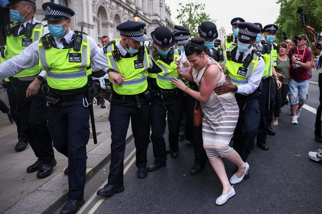 A woman attempts to obstruct the police officers from apprehending a demonstrator during an anti-lockdown and anti-vaccine protest, amid the coronavirus disease (COVID-19) pandemic, in London, Britain, June 14, 2021. (Photo by Henry Nicholls/Reuters)