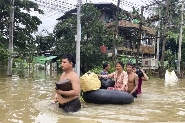 Volunteers push a woman with her belongings on inner-tube along a flooded road in Bago, Myanmar, about 80 kilometers (50 miles) northeast of Yangon, Friday, August 11, 2023. (Photo by AP Photo/Stringer)