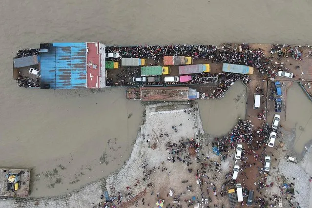 In this aerial photo taken on June 27, 2021, people board a ferry as authorities ordered a new lockdown to contain the spread of the Covid-19 coronavirus, in Munshiganj. (Photo by Munir Uz Zaman/AFP Photo)