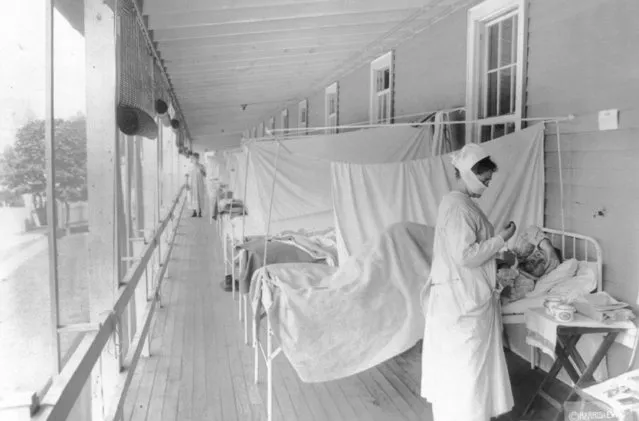 In this November 1918 photo made available by the Library of Congress, a nurse takes the pulse of a patient in the influenza ward of the Walter Reed hospital in Washington.  Historians think the pandemic started in Kansas in early 1918, and by winter 1919 the virus had infected a third of the global population and killed at least 50 million people, including 675,000 Americans. Some estimates put the toll as high as 100 million. By comparison, the AIDS virus has claimed 35 million lives over four decades. (Photo by Harris & Ewing/Library of Congress via AP Photo)