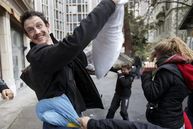 Young people fight for  fun with their pillows, during the International Pillow Fight Day at the Place des Grottes, in Geneva, Switzerland, Saturday, April 4, 2015. (Photo by Salvatore Di Nolfi/AP Photo/Keystone)