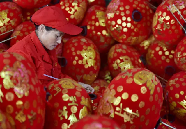 A woman works on red lanterns at a workshop ahead of New Year and Chinese Lunar New Year celebrations, in Wuyi county, Zhejiang province, China December 25, 2018. (Photo by Reuters/China Stringer Network)