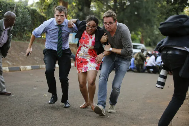 People take cover after an attack on a hotel, in Nairobi, Kenya, Tuesday, January 15, 2019.  Extremists launched a deadly attack on a luxury hotel in Kenya's capital Tuesday, sending people fleeing in panic as explosions and heavy gunfire reverberated through the complex. (Photo by Brian Inganga/AP Photo)