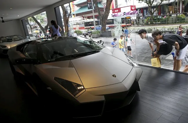 People look at a Lamborghini Reventon Roadster car on display at the shopping street of Orchard Road along with other rare and iconic super car models showcased by the Italian carmaker, in Singapore in this August 28, 2014 file photo. Sinagpore is expected to release inflation data this week. (Photo by Edgar Su/Reuters)