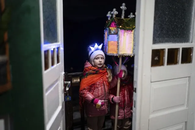 Children sing traditional "Kolyadky" songs during a Christmas celebration in Kryvorivnia village, Ukraine, Sunday, December 24, 2023. (Photo by Evgeniy Maloletka/AP Photo)