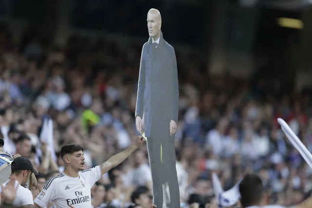 Real Madrid supporters holds a picture of Real Madrid's coach Zinedine Zidane in the stands during a Spanish La Liga soccer match between Real Madrid and Celta at the Santiago Bernabeu stadium in Madrid, Spain, Saturday, March 16, 2019. (Photo by Paul White/AP Photo)