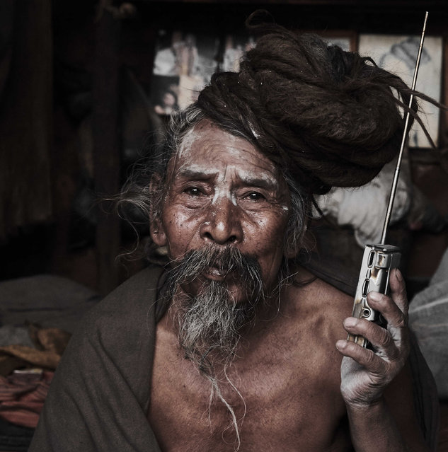 A holy man holding a radio, taken in Kathmandu, Nepal. (Photo by Jan Moeller Hansen/Barcroft Images)