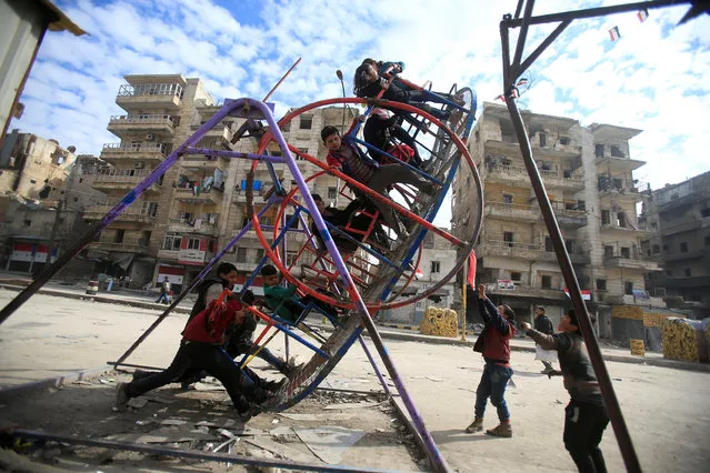 Children play on a swing in a damaged neighbourhood in Aleppo, Syria January 30, 2017. (Photo by Ali Hashisho/Reuters)
