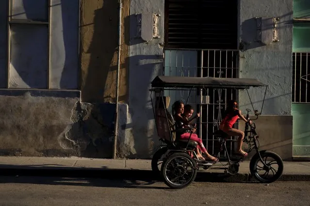 Children play on a tricycle taxi in Havana March 16, 2016. (Photo by Enrique de la Osa/Reuters)