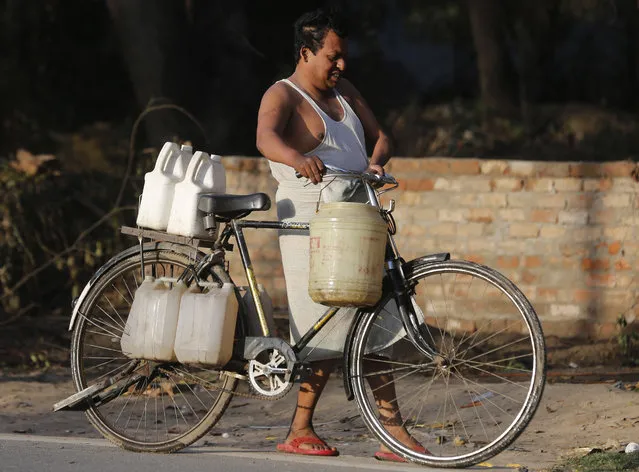  An Indian man pushes a bike loaded with containers filled with drinking water in Allahabad, India, Tuesday, March 22, 2016. The international charity Water Aid says 75.8 million Indians – or 5 percent of the country's 1.25 billion population – are forced to either buy water at high rates or use supplies that are contaminated with sewage or chemicals. That accounts for more than a tenth of the 650 million people worldwide without clean water access – more any single country in Africa or in China, where 63 million have no access. (Photo by Rajesh Kumar Singh/AP Photo)