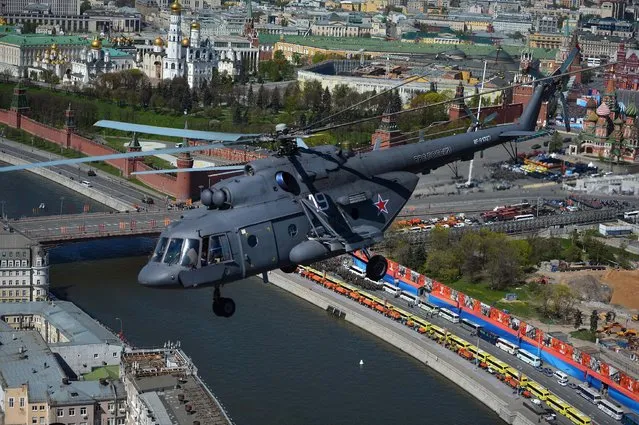 In this photo taken Thursday, May 7, 2015, a Russian airforce Mi-8 helicopter flies over the Moskva River, with the Kremlin in the background during a rehearsal of a V-Day military parade in Moscow, Russia. A V-Day military parade marking the 70th anniversary of the defeat of the Nazis in World War II will be held on May 9. (Photo by Host photo agency/RIA Novosti Pool Photo via AP Photo)