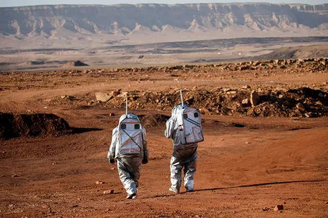 Scientists participate in a demonstration of an experiment led by Austrian and Israeli agencies simulating a mission to Mars near Mitzpe Ramon, Israel on October 10, 2021. Here, in the Ramon Crater in the desert of southern Israel, a team of six - five men and one woman - have begun simulating what it will be like to live for about a month on the red planet. Their AMADEE-20 habitat is tucked beneath a rocky outcrop. Inside they sleep, eat and conduct experiments. Outside they wear mock space suits fitted with cameras, microphones and self-contained breathing systems. (Photo by Amir Cohen/Reuters)
