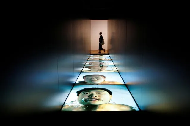 A woman walks past the “1/30th of a Second Underwater” by Wang Wei  during a media preview at “M+” visual culture museum in Hong Kong, China on November 11, 2021. (Photo by Tyrone Siu/Reuters)