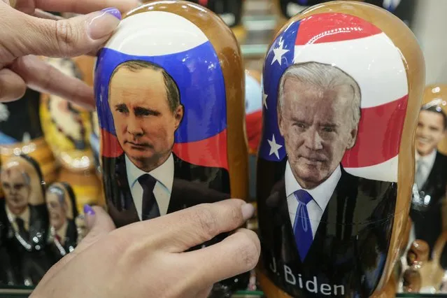 A customer shows to photographer a traditional Russian wooden dolls called Matreska of Russian President Vladimir Putin, center, and U.S. President Joe Biden, center right, at a souvenirs store in Moscow, Russia, Monday, December 6, 2021. The Kremlin says President Joe Biden and Russian President Vladimir Putin will speak in a video call Tuesday. (Photo by Pavel Golovkin/AP Photo)