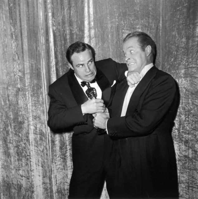 Actor Marlon Brando wrestles his best actor Oscar away from comedian Bob Hope at the Academy Awards ceremony at the RKO Pantages Theatre on March 30, 1955 in Los Angeles, California. (Photo by Frank Worth, Courtesy of Capital Art/Getty Images) 