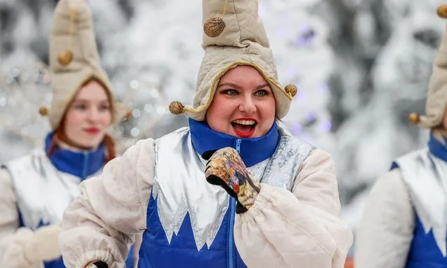Performers are seen as a 90-year old spruce tree cut down in the woods of the Shchyolkovsky District in Moscow Region, Russia on December 16, 2021 is sent to Moscow. The almost 28-metre high tree will be put up at the Moscow Kremlin's Sobornaya (Cathedral) Square this New Year and Christmas. (Photo by Vasily Fedosenko/TASS)