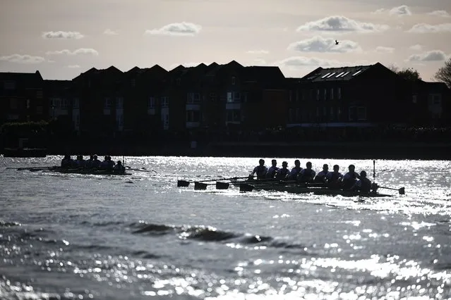Teams are silhouetted as they compete in the 169th men's boat race between Oxford University and Cambridge University on the River Thames in London on March 30, 2024. The Boat Race was first raced by crews from Oxford and Cambridge University in 1829 and is now one of the world's oldest and most famous amateur sporting events. (Photo by Henry Nicholls/AFP Photo)