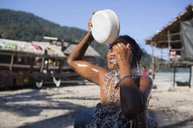 Koh, an indigenous Moken woman, washes her face with freshwater after making charcoal in the jungle. February 27, 2013 – Ko Surin, Thailand. (Photo by Taylor Weidman/zReportage via ZUMA Press)