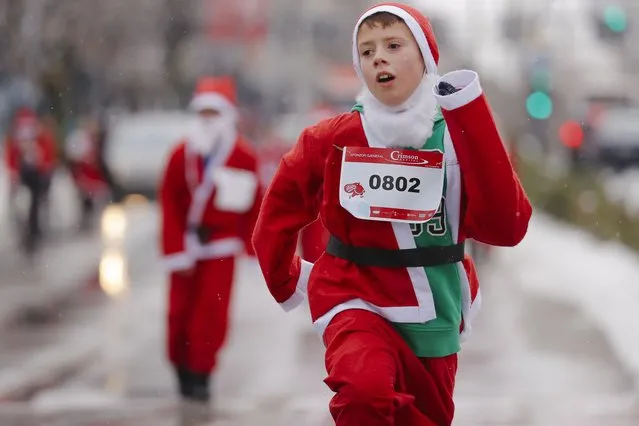 Participants wearing Santa Claus costumes take part in a charity run in Pristina, Kosovo, 12 December 2021. Kosovo's catholic believers celebrate Christmas according to the Gregorian calendar on 25 December. (Photo by Valdrin Xhemaj/EPA/EFE)