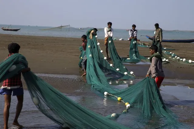 Rohingya fishermen prepare fishing net to catch as they work at a dried fish production site near the Chaung IDP camp in Sittwe, Rakhine State, Myanmar on January 1, 2022. (Photo by Aung Hlaing Soe/Anadolu Agency via Getty Images)
