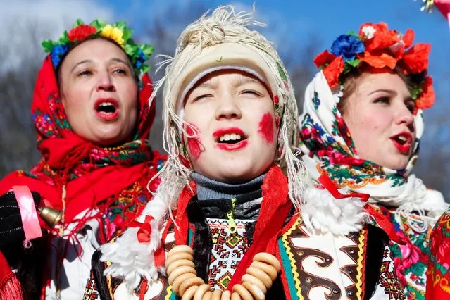 Women dressed in traditional costumes sing Christmas carols as they gather to celebrate Orthodox Christmas at a compound of the National Architecture museum in Kyiv, Ukraine on January 7, 2022. (Photo by Valentyn Ogirenko/Reuters)