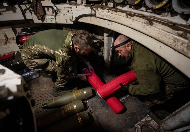 Ukrainian servicemen of the 92nd separate assault brigade load shells in an M109 self-propelled howitzer before firing towards Russian troops, amid Russia's attack on Ukraine, near the town of Vovchansk in Kharkiv region, Ukraine, on May 20, 2024. (Photo by Inna Varenytsia/Reuters)