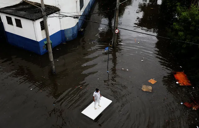 A worker uses a table to move along a flooded street after heavy rainfall in Sao Paulo, Brazil April 7, 2017. (Photo by Nacho Doce/Reuters)