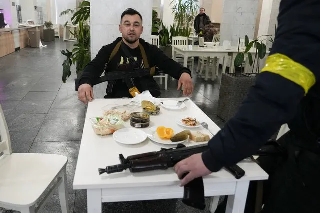 Members of civil defense eat during a pause in their duty in the City Hall in Kyiv, Ukraine, Sunday, February 27, 2022. (Photo by Efrem Lukatsky/AP Photo)