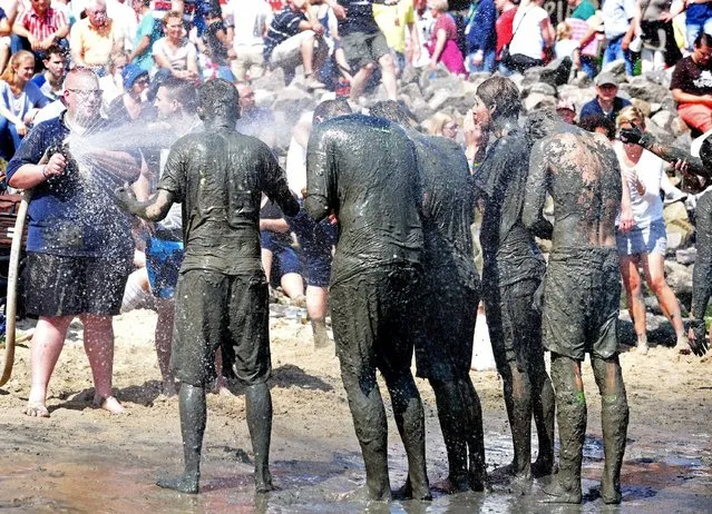 Players gets a shower aftert their match at the so called “Wattoluempiade” (Mud Olympics) in Brunsbuettel at the North Sea, July 11, 2015. (Photo by Fabian Bimmer/Reuters)