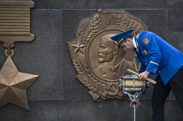 A member of a military band handles a drum, backdropped by a depiction of Soviet revolutionary leader Vladimir Lenin, before Victory Day celebrations in Odessa, Ukraine, Friday, May 9, 2014. (Photo by Vadim Ghirda/AP Photo)