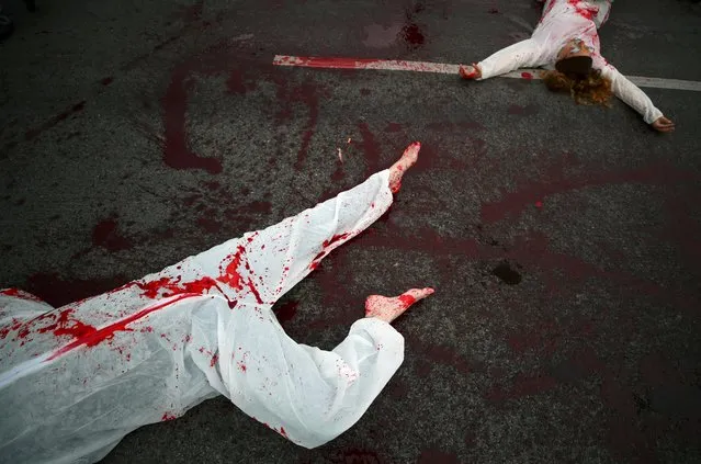 Climate change activists stage a die-in as they block a road during the Extinction Rebellion protest in Vienna, Austria, October 9, 2019. (Photo by Lisi Niesner/Reuters)