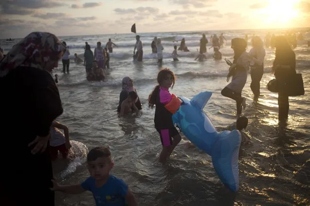 Muslims, many of whom are Palestinians from the West Bank, bathe in the Mediterranean Sea during the last day of the Eid al-Fitr holiday as the sun sets in Tel Aviv, Israel, Sunday, July 19, 2015. (Photo by Ariel Schalit/AP Photo)