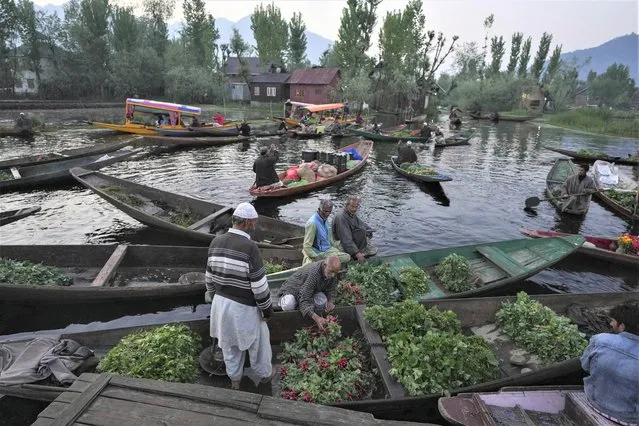 Kashmiri men sell their produce at the floating vegetable market on the Dal Lake in Srinagar, Indian controlled Kashmir, Thursday, April 7, 2022. (Photo by Rajesh Kumar Singh/AP Photo)