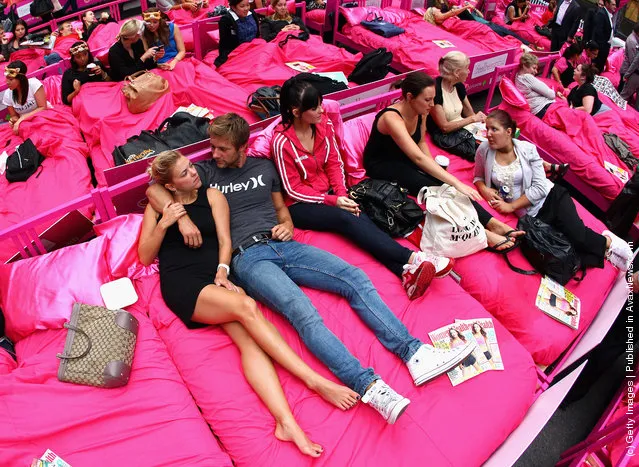 People wait in beds during the The World's Biggest Breakfast in Bed Guinness World Record Attempt at Martin Place in Sydney, Australia