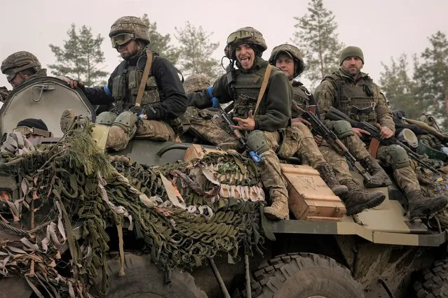 Ukrainian servicemen ride on an armored transporter driving through a Russian position overran by Ukrainian forces outside Kyiv, Ukraine, Thursday, March 31, 2022. Heavy fighting raged on the outskirts of Kyiv and other zones Thursday amid indications the Kremlin is using talk of de-escalation as cover while regrouping and resupplying its forces and redeploying them for a stepped-up offensive in eastern Ukraine. (Photo by Vadim Ghirda/AP Photo)