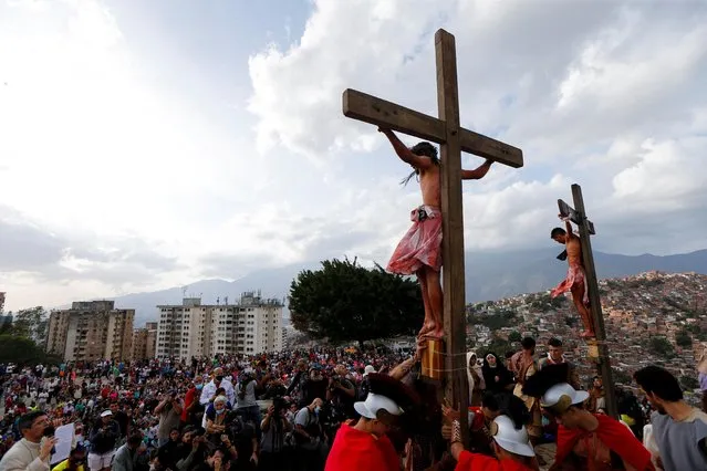 Amateur actors take part in the reenactment of the crucifixion of Jesus Christ during the Good Friday procession in the low-income neighborhood of Petare, in Caracas, Venezuela on April 15, 2022. (Photo by Leonardo Fernandez Viloria/Reuters)