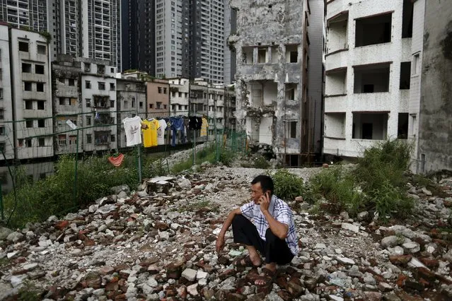 A resident rests on wreckage of houses in Xian village, a slum area in downtown Guangzhou, China July 24, 2015. (Photo by Tyrone Siu/Reuters)