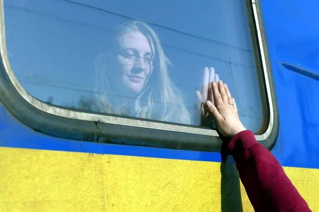 A woman says goodbye to her relative aboard a train travelling to Przemysl, Poland, amid Russia's invasion of Ukraine, in Odesa, Ukraine, April 25, 2022. (Photo by Igor Tkachenko/Reuters)