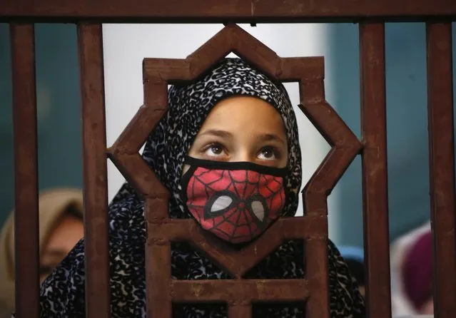 A Kashmiri girl looks on as a priest (not pictured) displays the relic of Sheikh Syed Abdul Qadir Jeelani at his shrine in Srinagar, India, 09 December 2019. Hundreds of devotees gathered at the shrine during their 11-day festival to mark the death anniversary of the Sufi saint. (Photo by Farooq Khan/EPA/EFE)