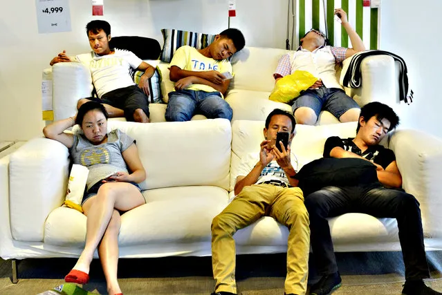 People rest and sleep on couches at a IKEA store to escape the summer heat in Hangzhou, Zhejiang province, China, August 4, 2015. The local temperature reached as high as 39 degrees Celsius (102 degrees Fahrenheit) on Tuesday, according to local media. (Photo by Reuters/China Daily)