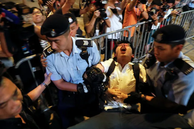 Student protest leader Joshua Wong shouts as he is carried by policemen as protesters are arrested at a monument symbolising the city's handover from British to Chinese rule, a day before Chinese President Xi Jinping is due to arrive for the celebrations, in Hong Kong, China June 28, 2017. (Photo by Damir Sagolj/Reuters)